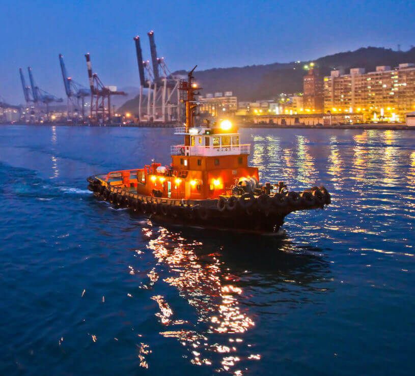 A tug boat on a river through a city