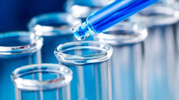 Dropper placing a drop of liquid into a test tube